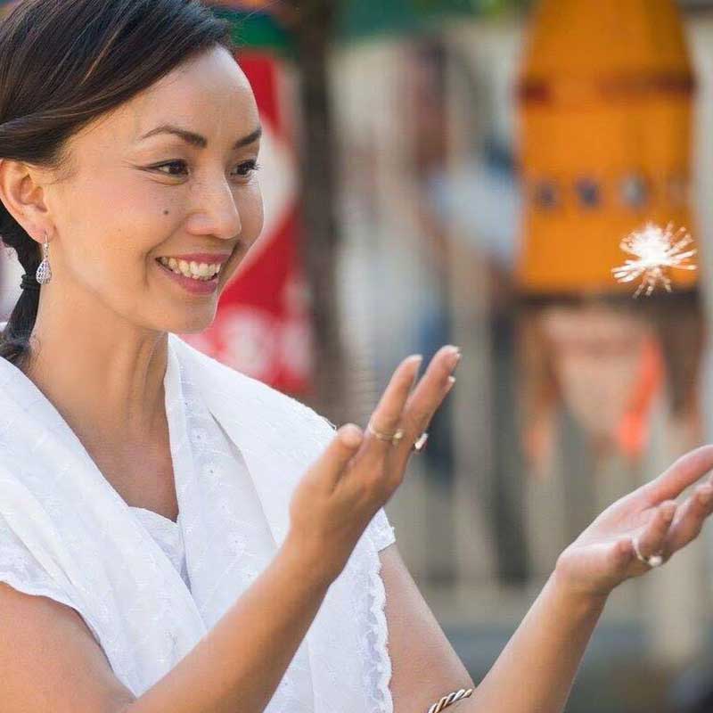 Mai Lee playing with a dandelion
